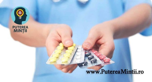 Un doctor tine mai multe folii de medicamente colorate in mana